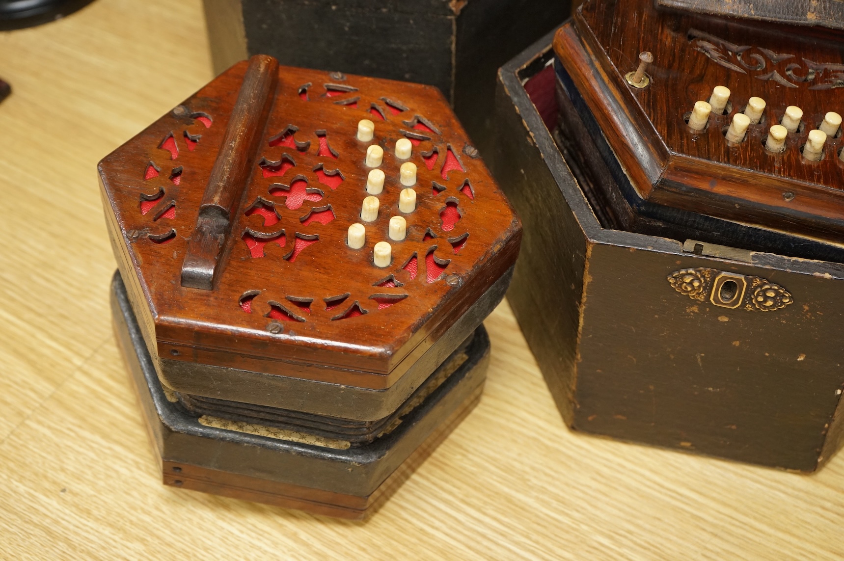 Two cased concertinas; one in mahogany with original paper label for Lachenal & Co., London, the other in rosewood (a.f.)